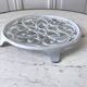 Vintage white cast iron trivet from the early 20th century
