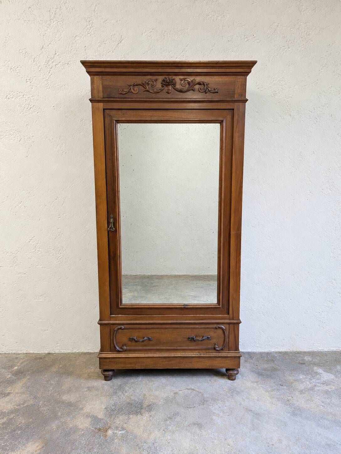 Armoire ancienne à miroir et décors sculptés