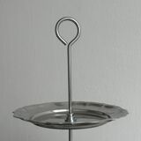 Three-tiered serving trolley in shiny stainless steel.