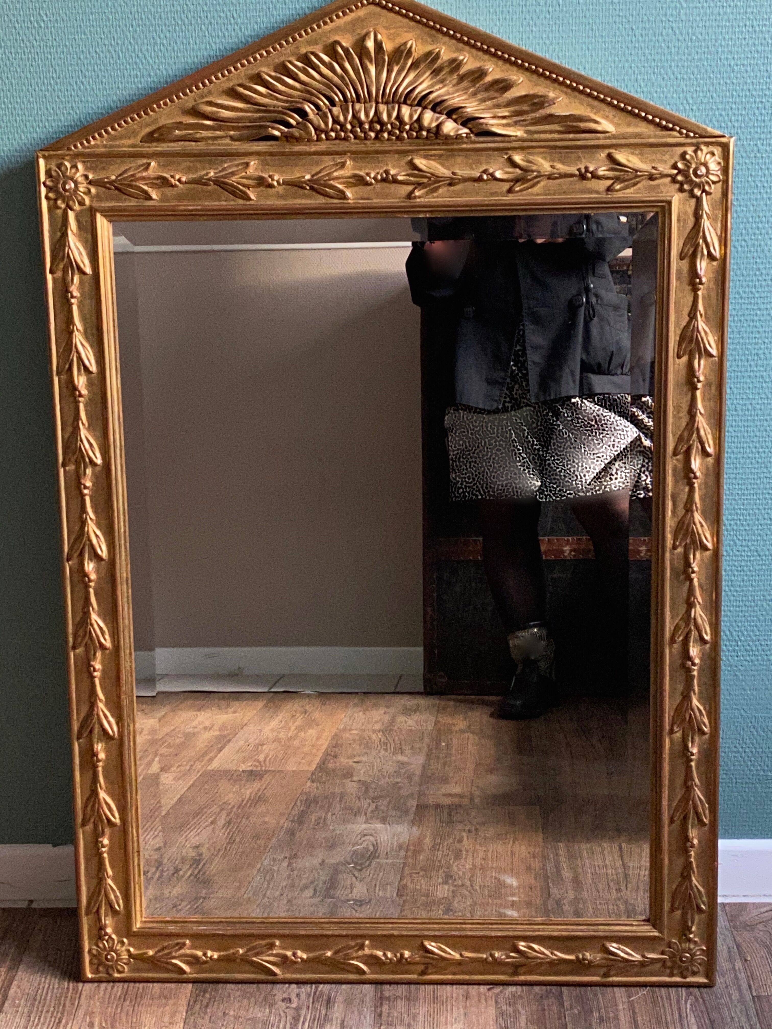 Mirror in gilded wood with a triangle pediment decorated with half sunflowers