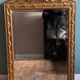 Mirror in gilded wood with a triangle pediment decorated with half sunflowers