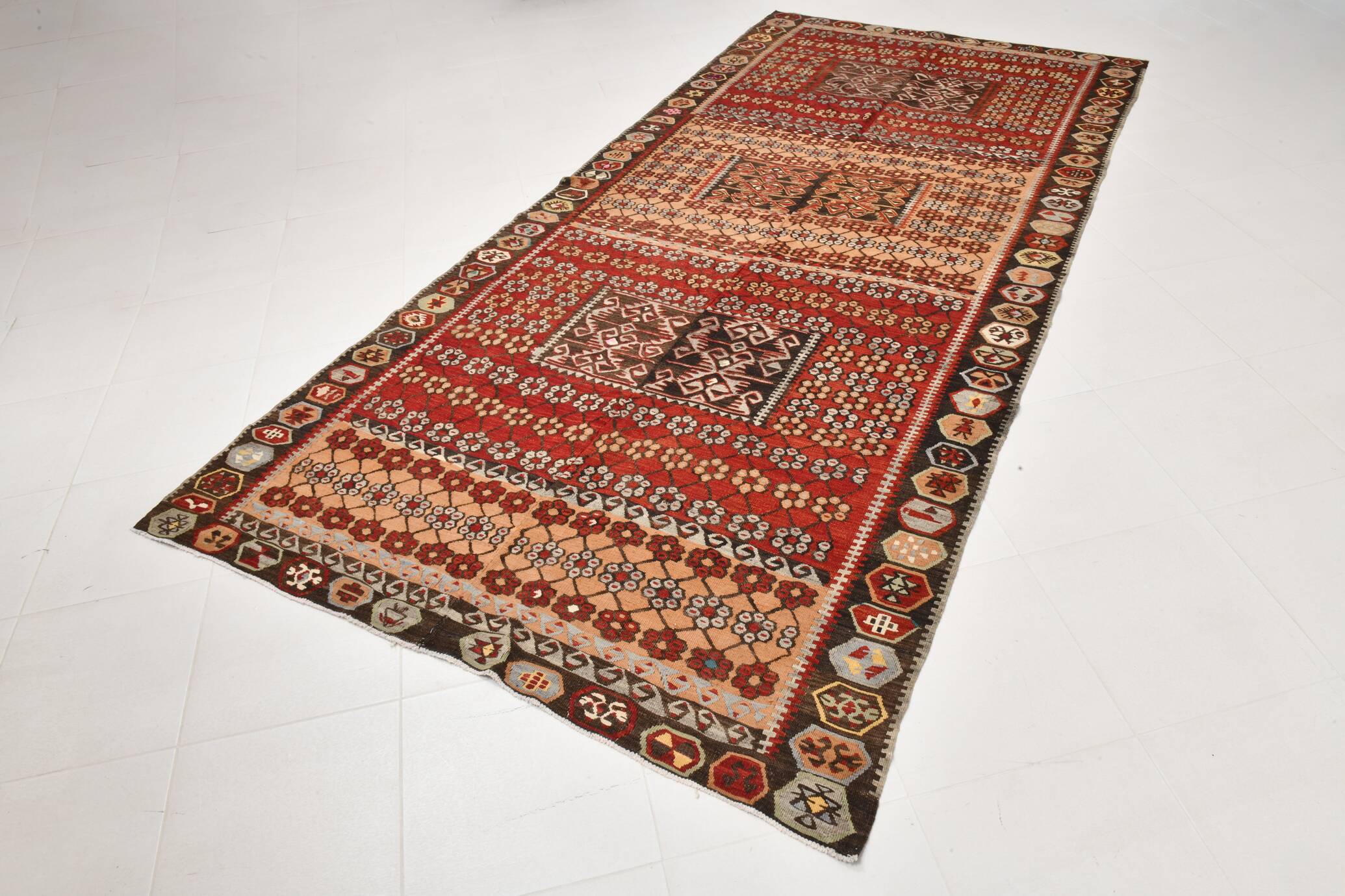 Kilim anatolien ancien tons rouges et beiges, motifs tribaux colorés