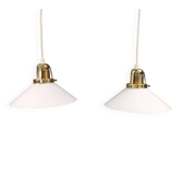 Two small hanging lamps in milky white glass with brass-coloured tops.