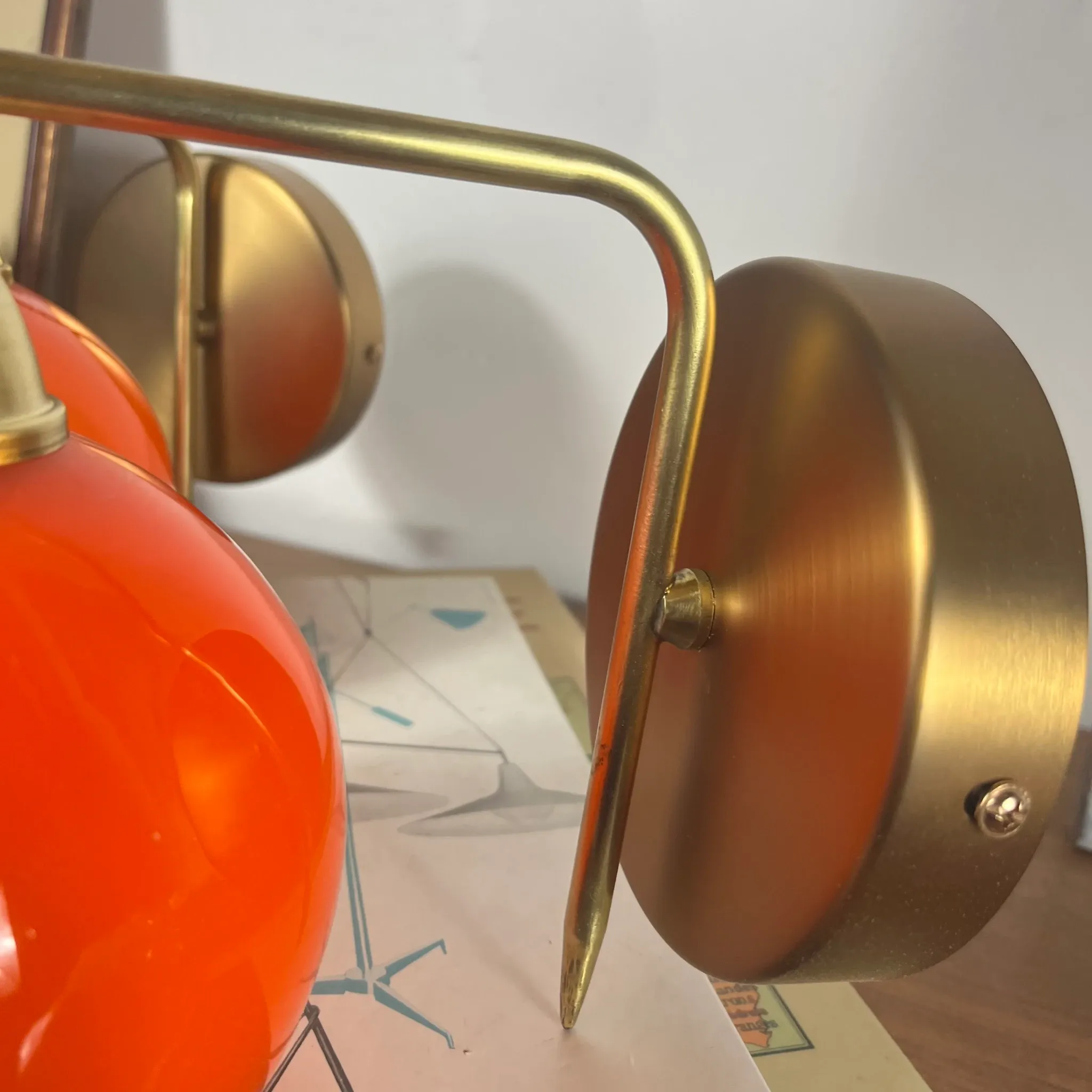 Pair of wall sconces with orange opaline glass globes and brass.