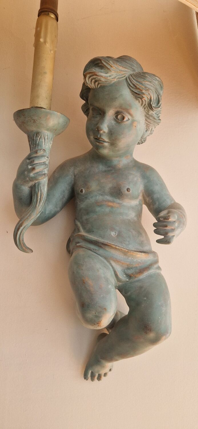 Pairs of wall lights, either two distinct cherubs.