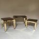 Set of three nesting side tables in brass and smoked mirror.
