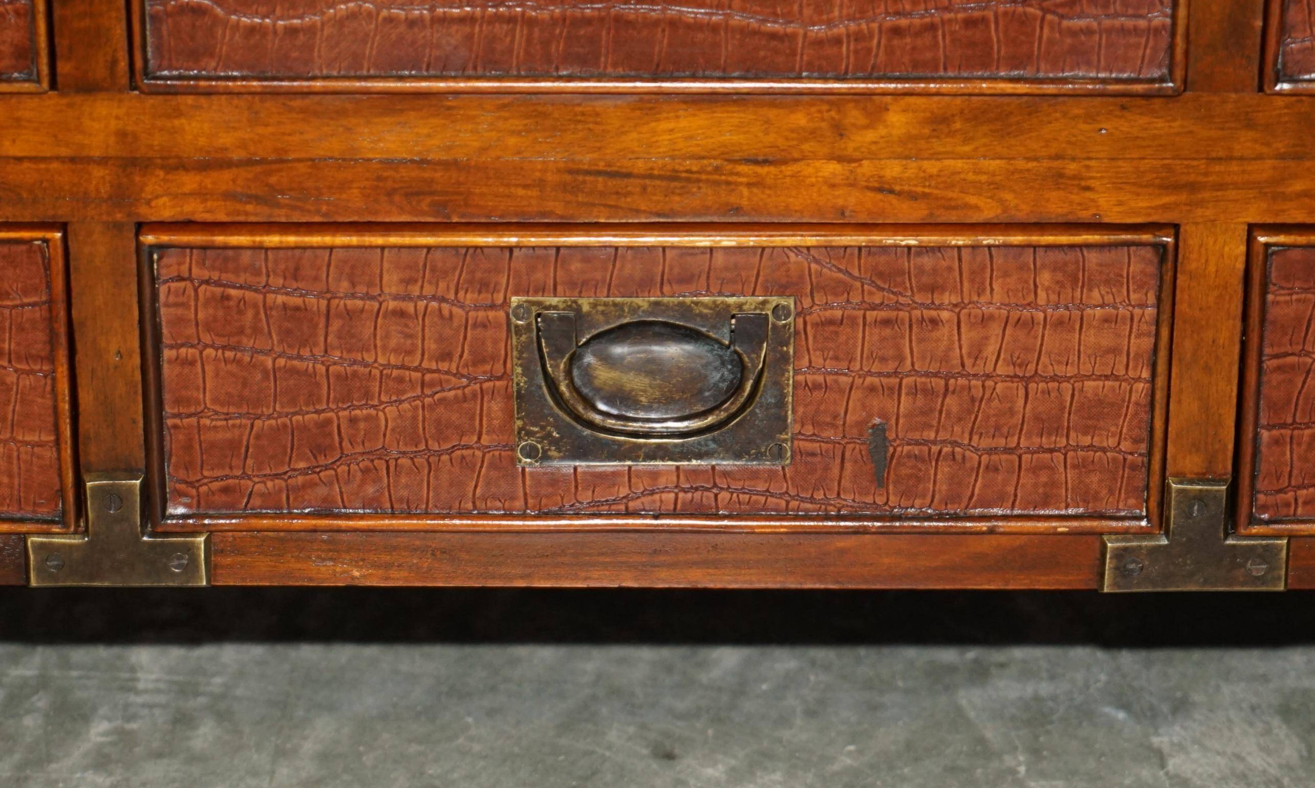 Pair of open bookshelves in crocodile leather with drawers and compartments.