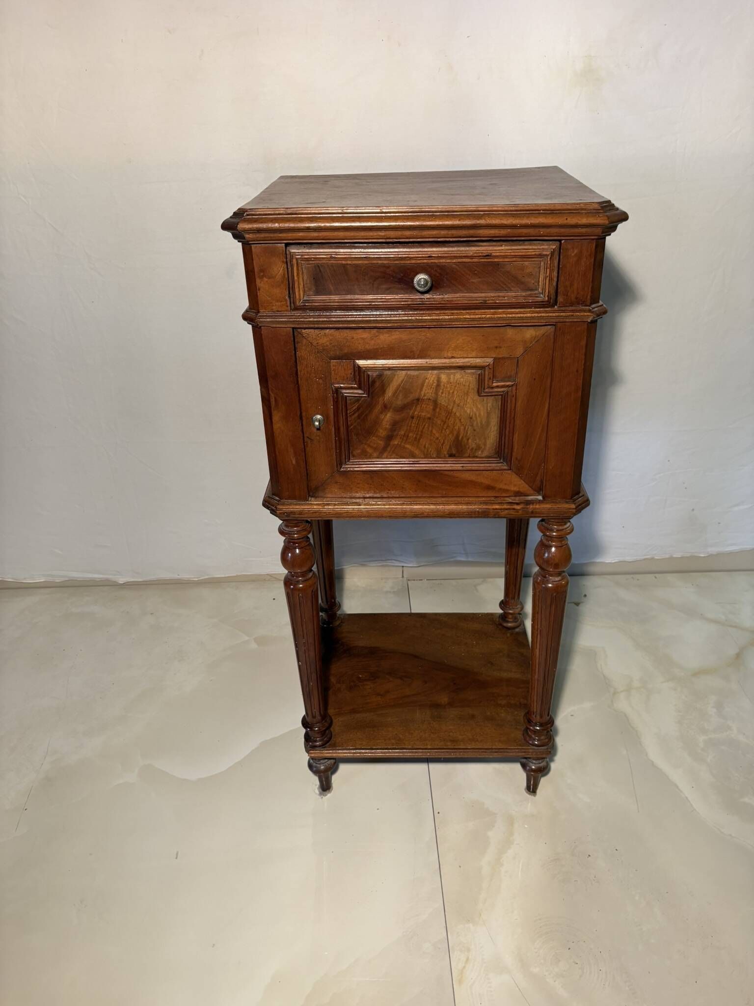 Antique wooden bedside table with turned legs.