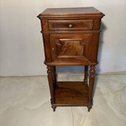 Antique wooden bedside table with turned legs.