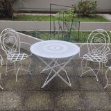 Folding round table and four wrought iron armchairs