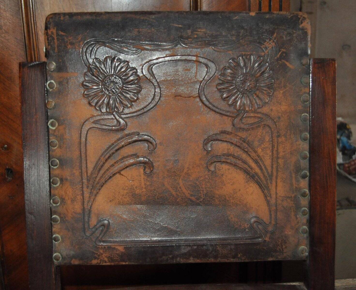 Pair of brown embossed leather chairs with brass studs and wooden frame, 1900s