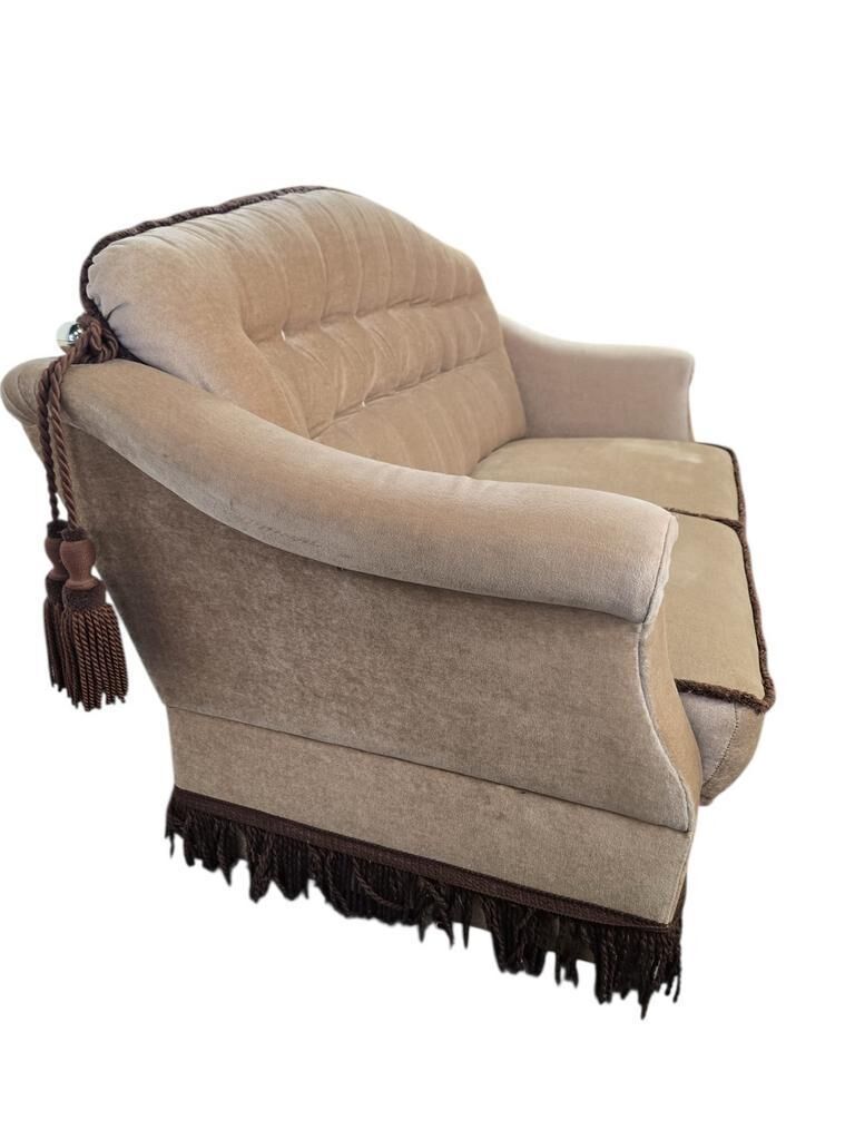 Vintage beige two-seater canapé with fringes.