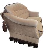 Vintage beige two-seater canapé with fringes.