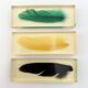 Six feather-shaped knife rests in resin inclusion.