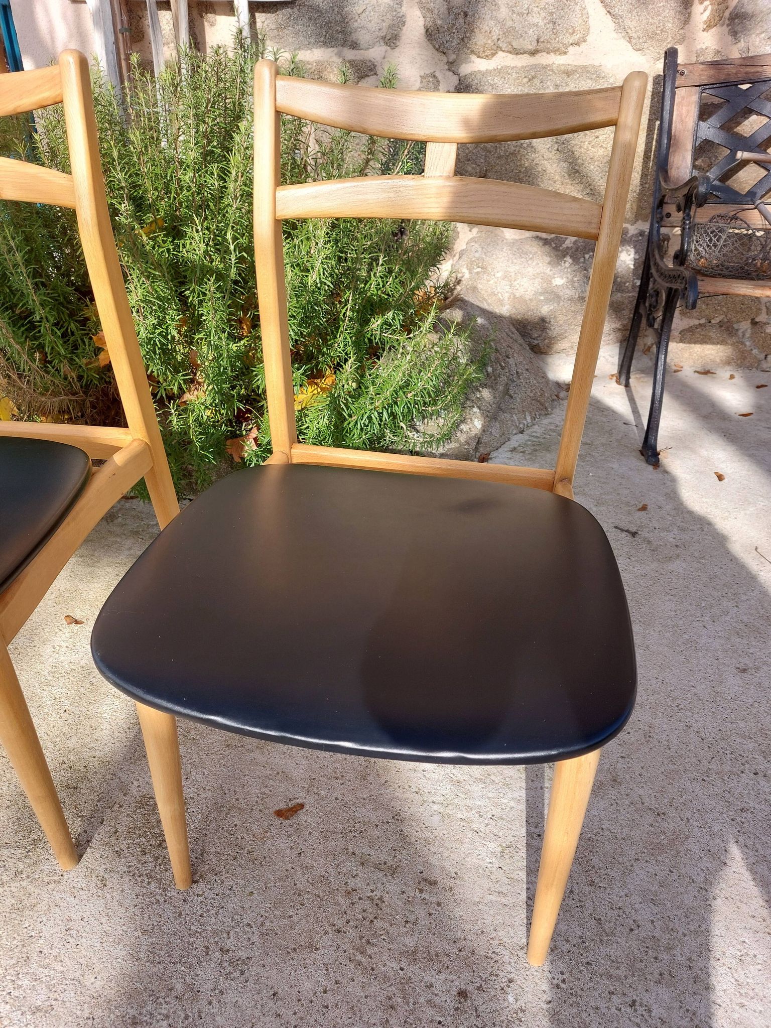 3 Scandinavian style chairs, light wood and black faux leather.