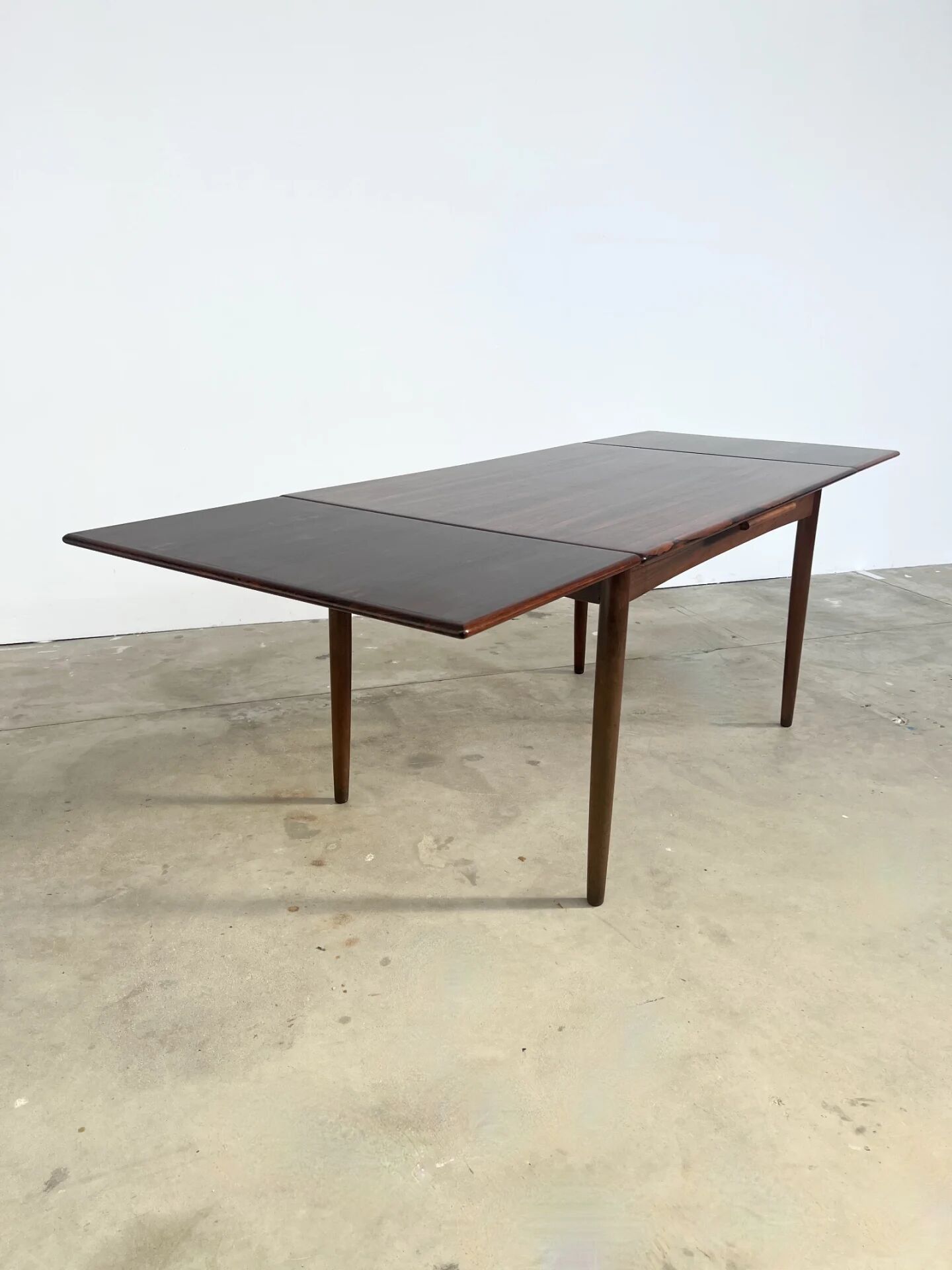 Rosewood dining table with integrated extensions — Denmark, 1960s