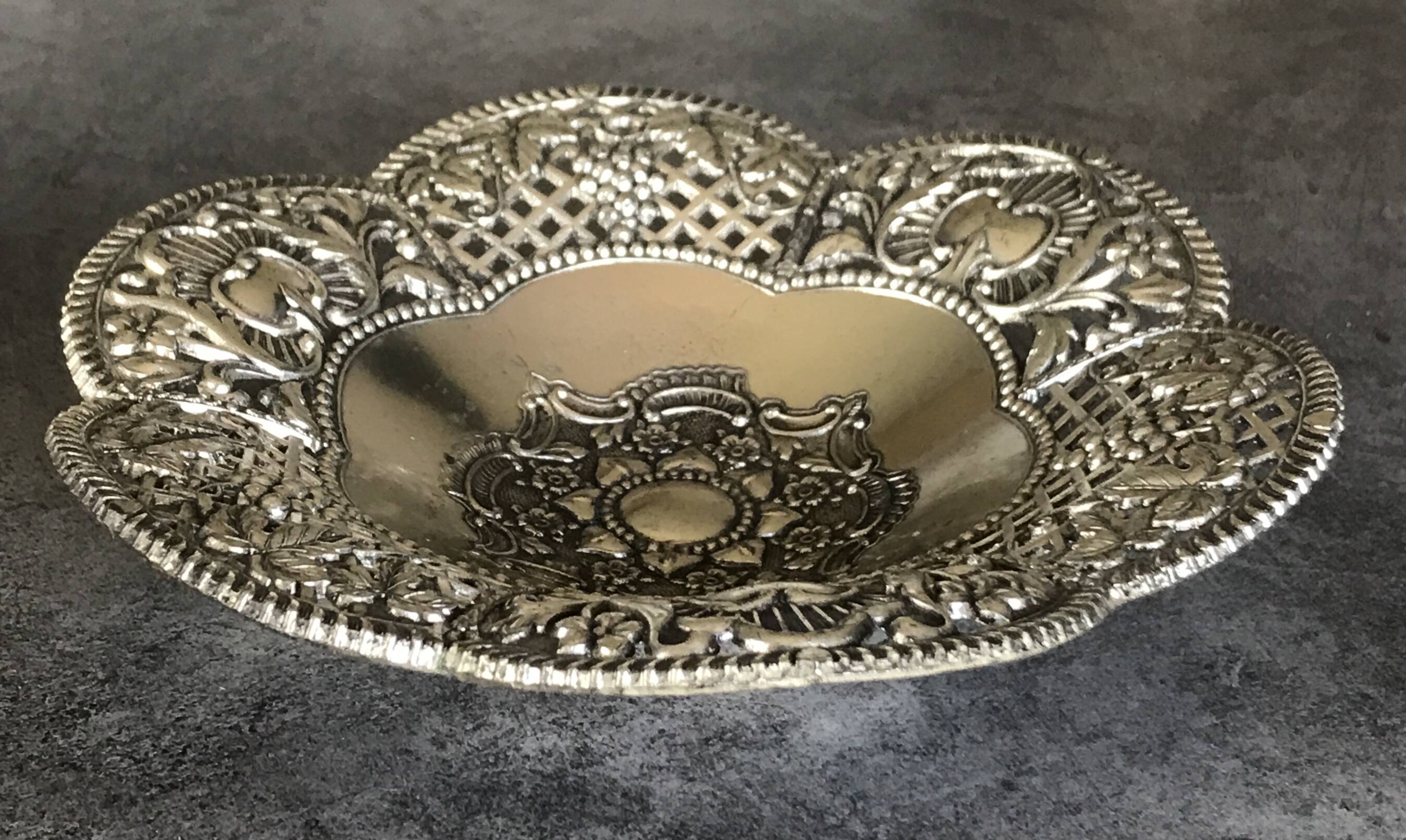 Silver-plated metal pocket emptier with openwork outline decoration