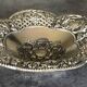 Silver-plated metal pocket emptier with openwork outline decoration