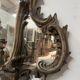 Mirror with a decorative frame featuring a four-light wall sconce, 19th century.