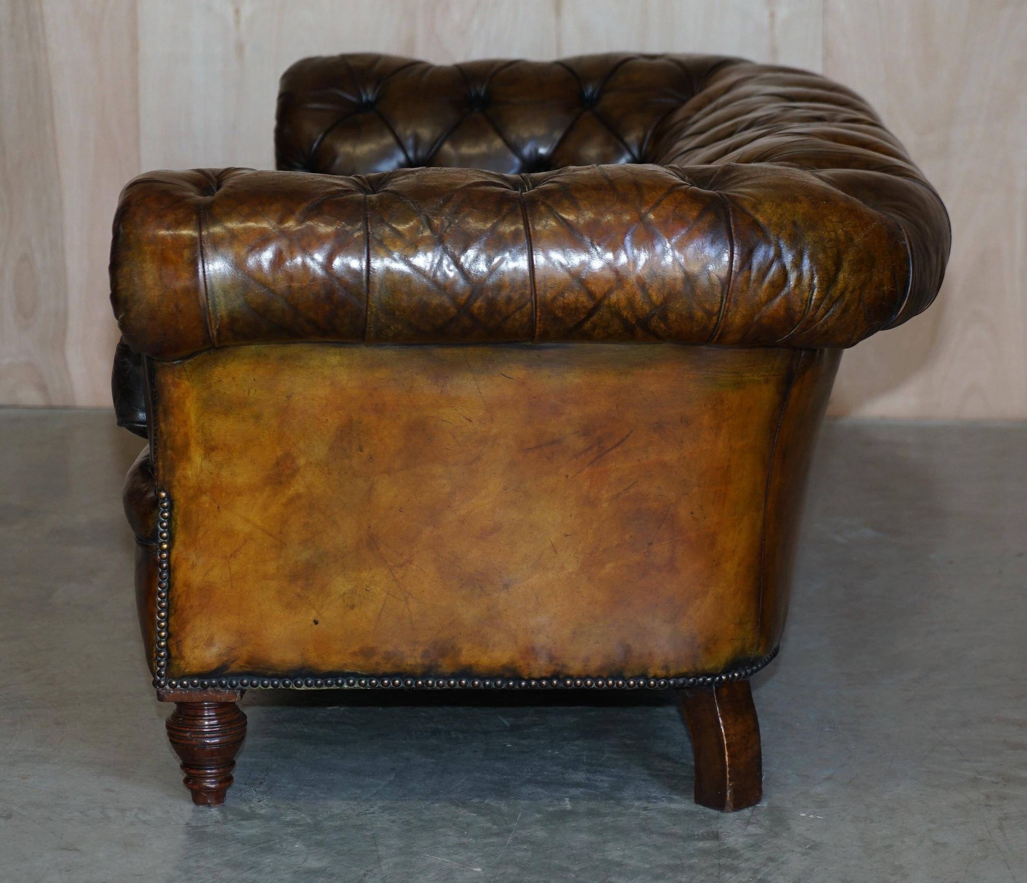 Victorian Chesterfield leather upholstered canapé with feather cushions.