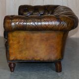 Victorian Chesterfield leather upholstered canapé with feather cushions.