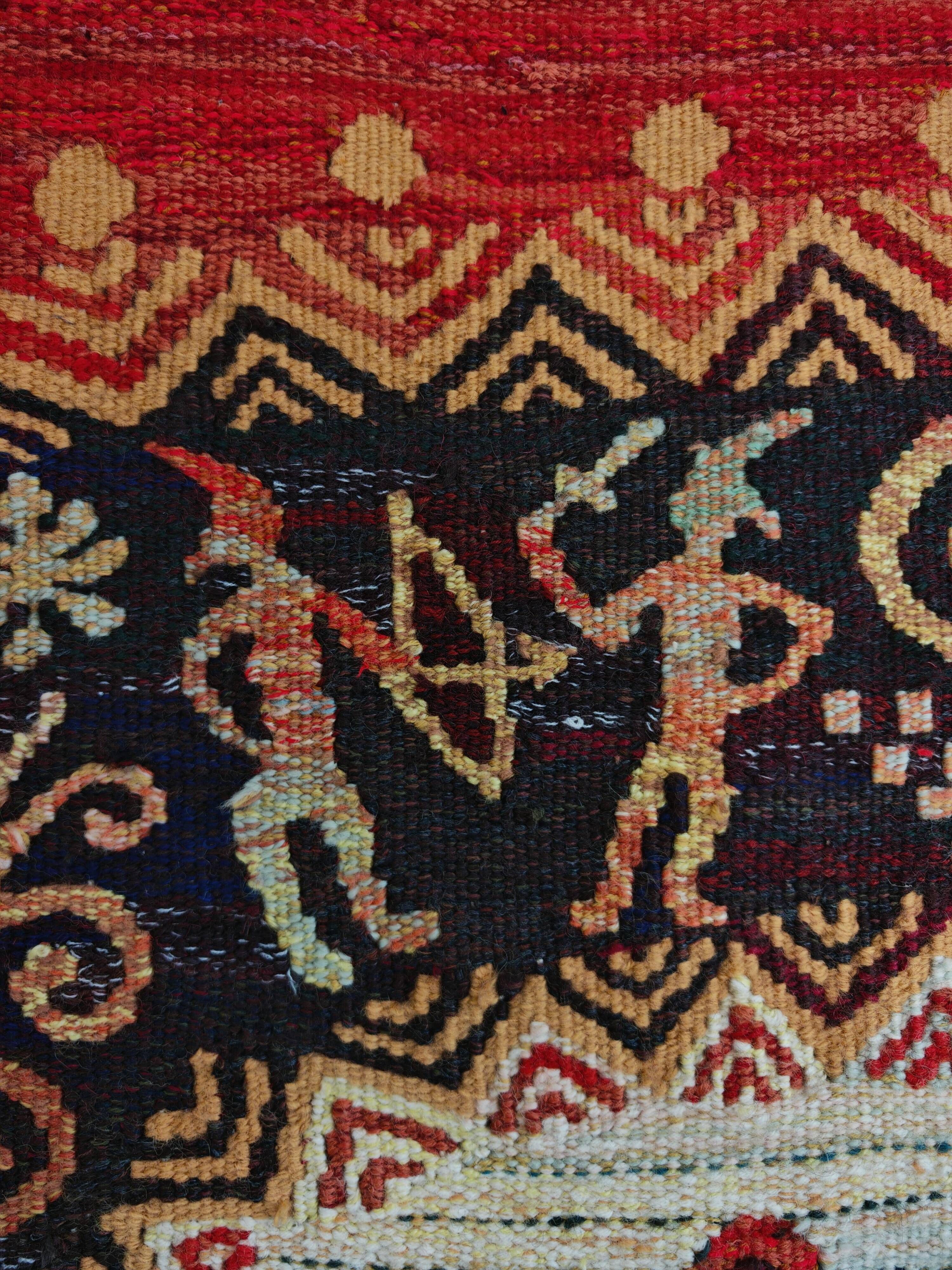 Vintage handwoven tapestry with a folk scene and archaic Slavic writing.