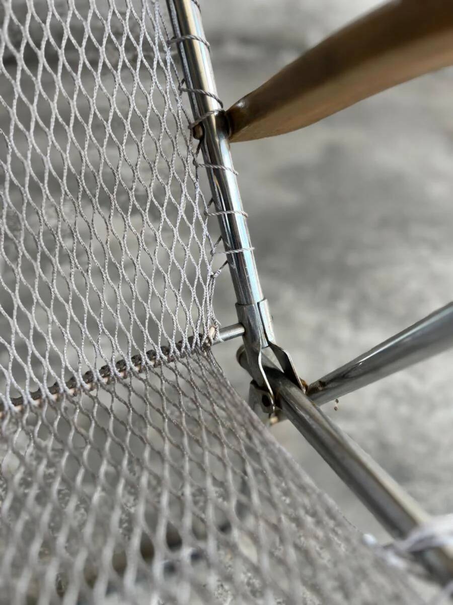 Pair of vintage silver aluminum wire folding chairs with wooden armrests — industrial minimalist