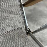 Pair of vintage silver aluminum wire folding chairs with wooden armrests — industrial minimalist