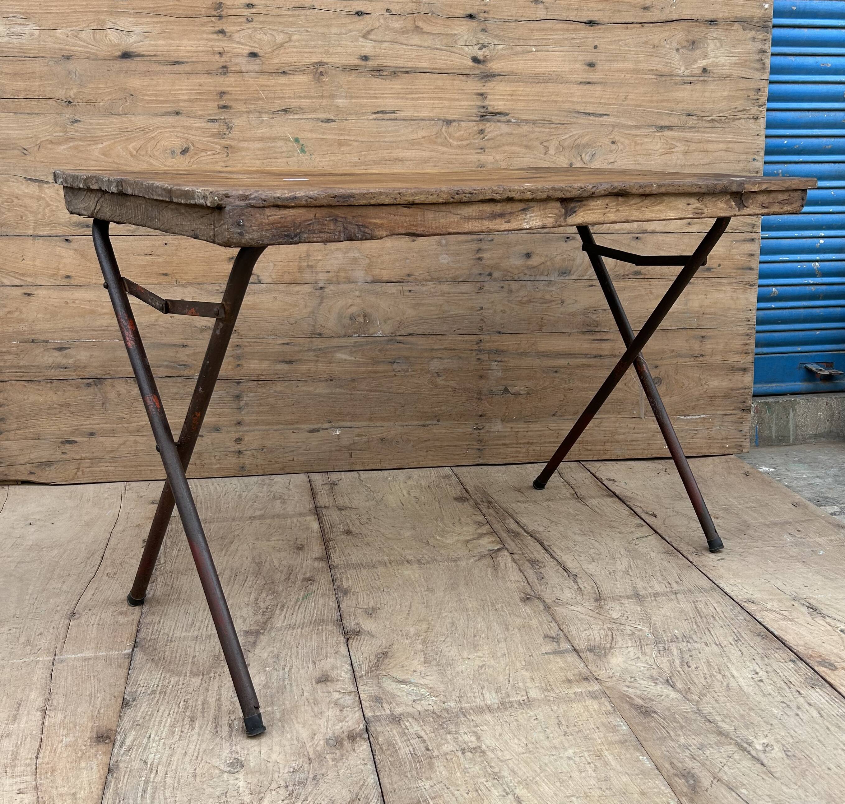 Folding workshop table with a metal frame and solid teak top.