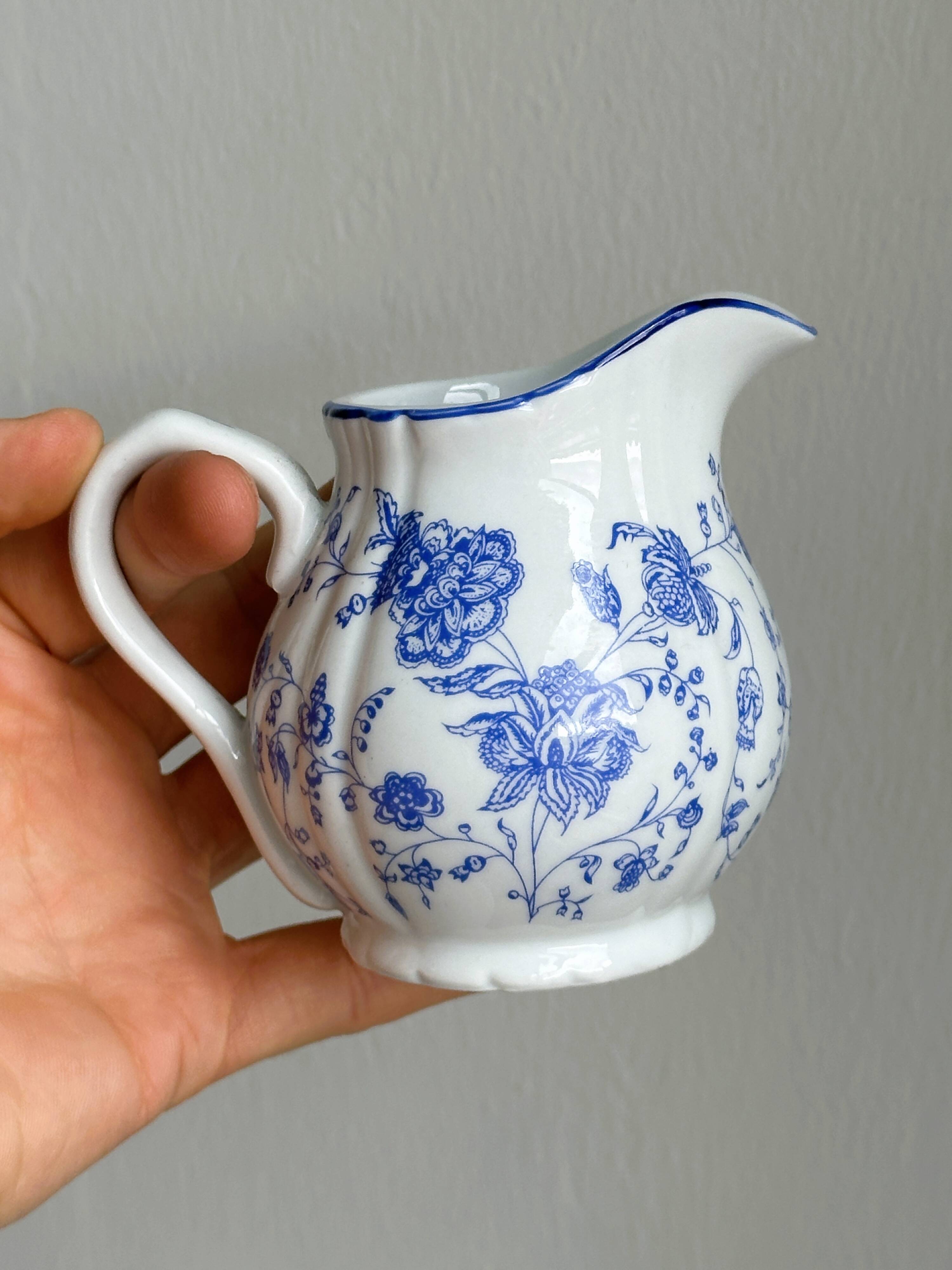 White porcelain milk jug with blue floral designs.