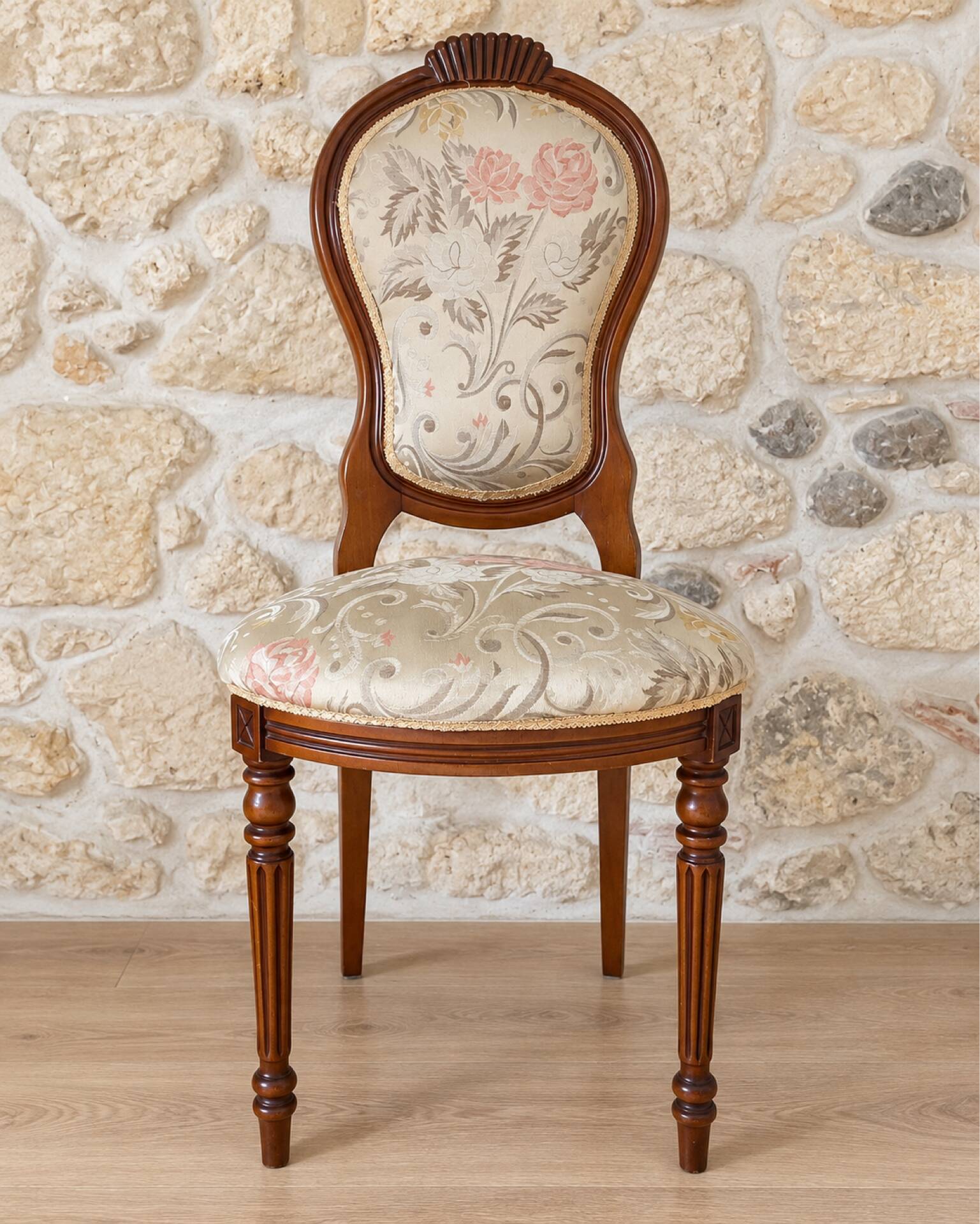 Antique Louis XVI style chair in wood and floral fabric.