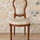 Antique Louis XVI style chair in wood and floral fabric.
