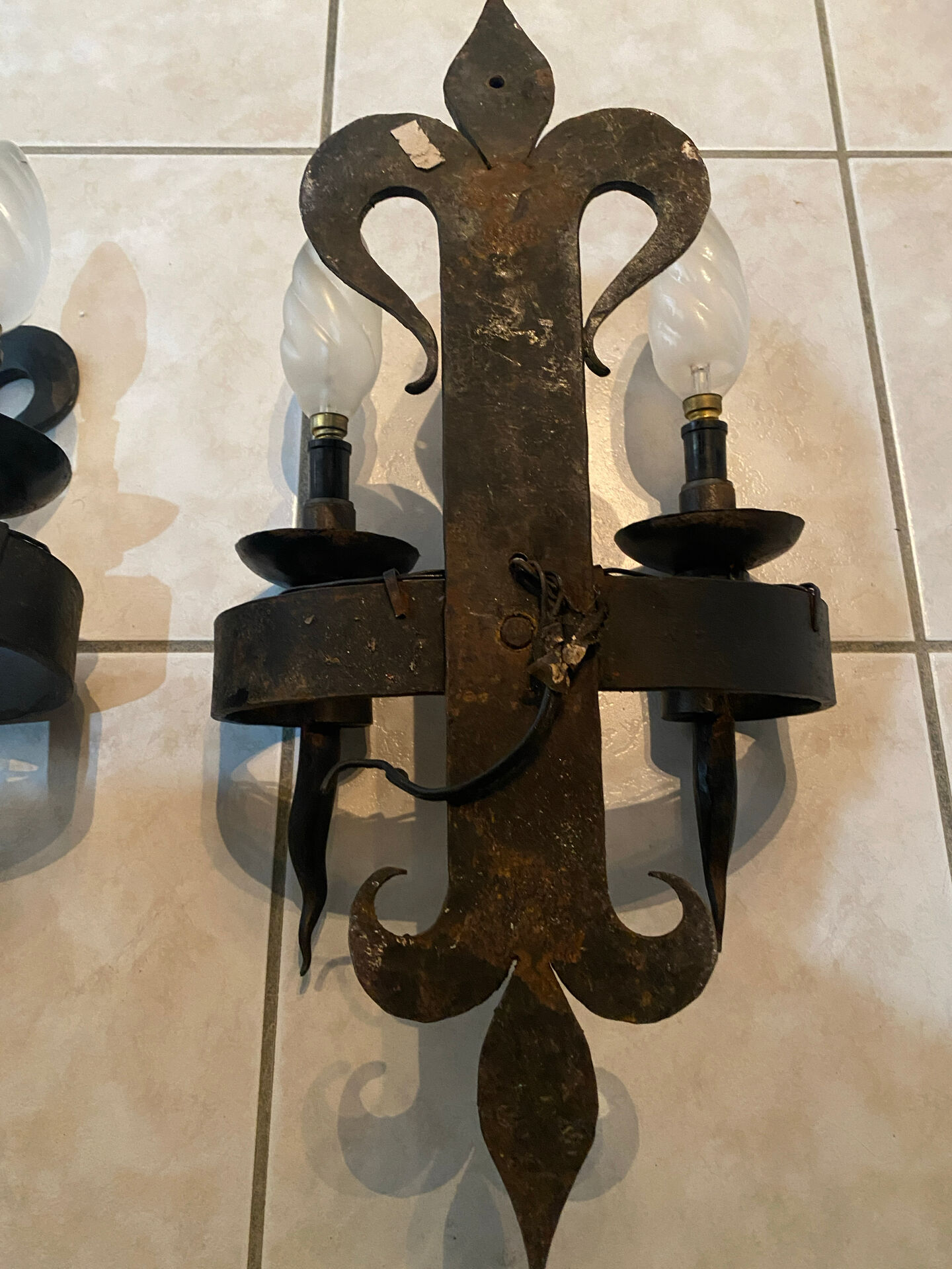 Pair of wrought iron wall lights in fleur-de-lis château style.