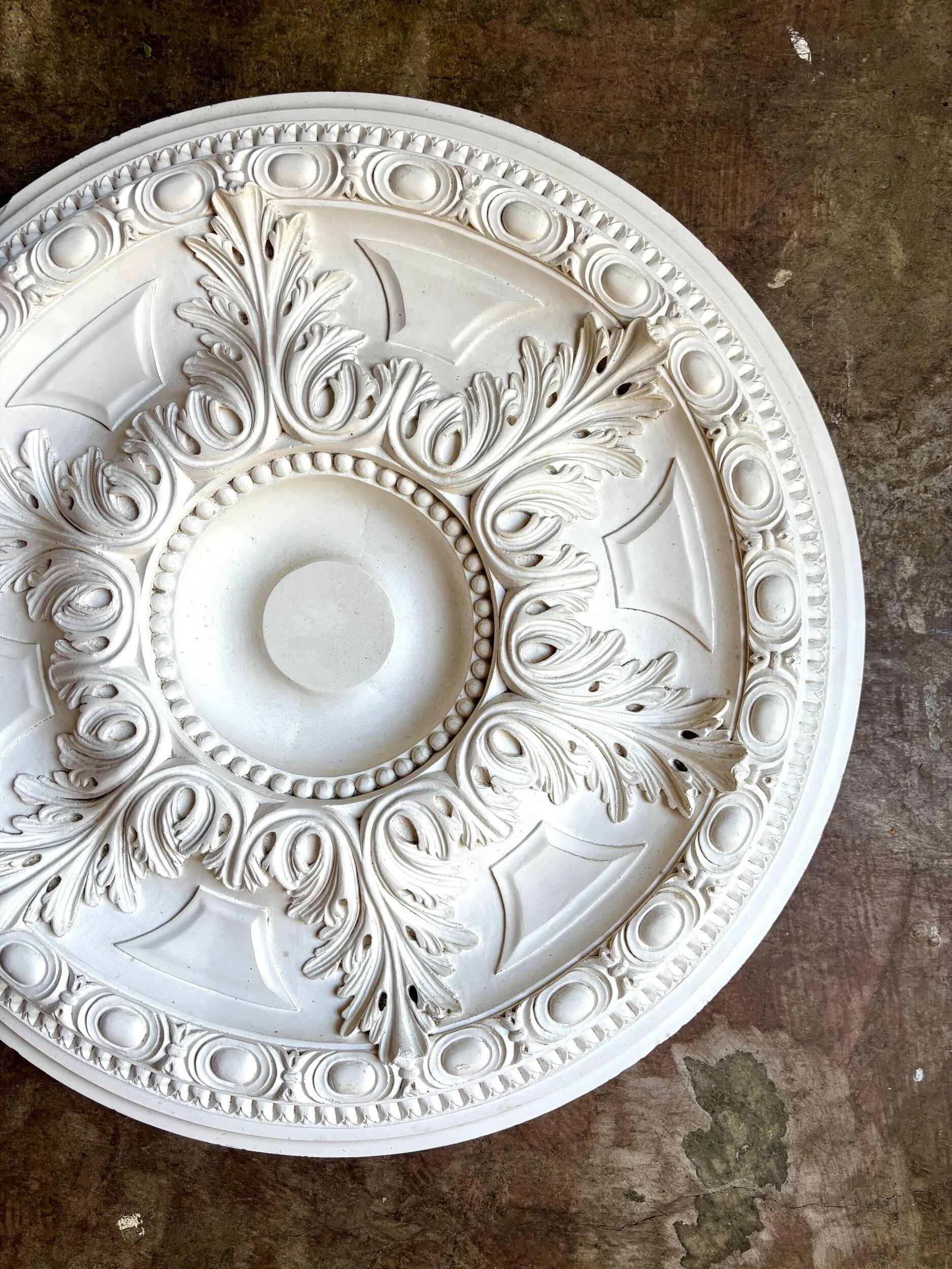 Rosette on white background, decorated with scrolls and beaded frieze ⌀ 61 cm