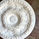 Rosette on white background, decorated with scrolls and beaded frieze ⌀ 61 cm