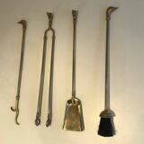 Neoclassical brass fire accessory with duck head decorations.