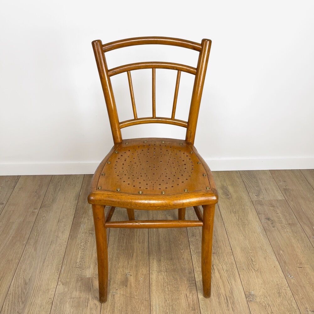 Pair of curved wood bistro chairs and studded and perforated seat
