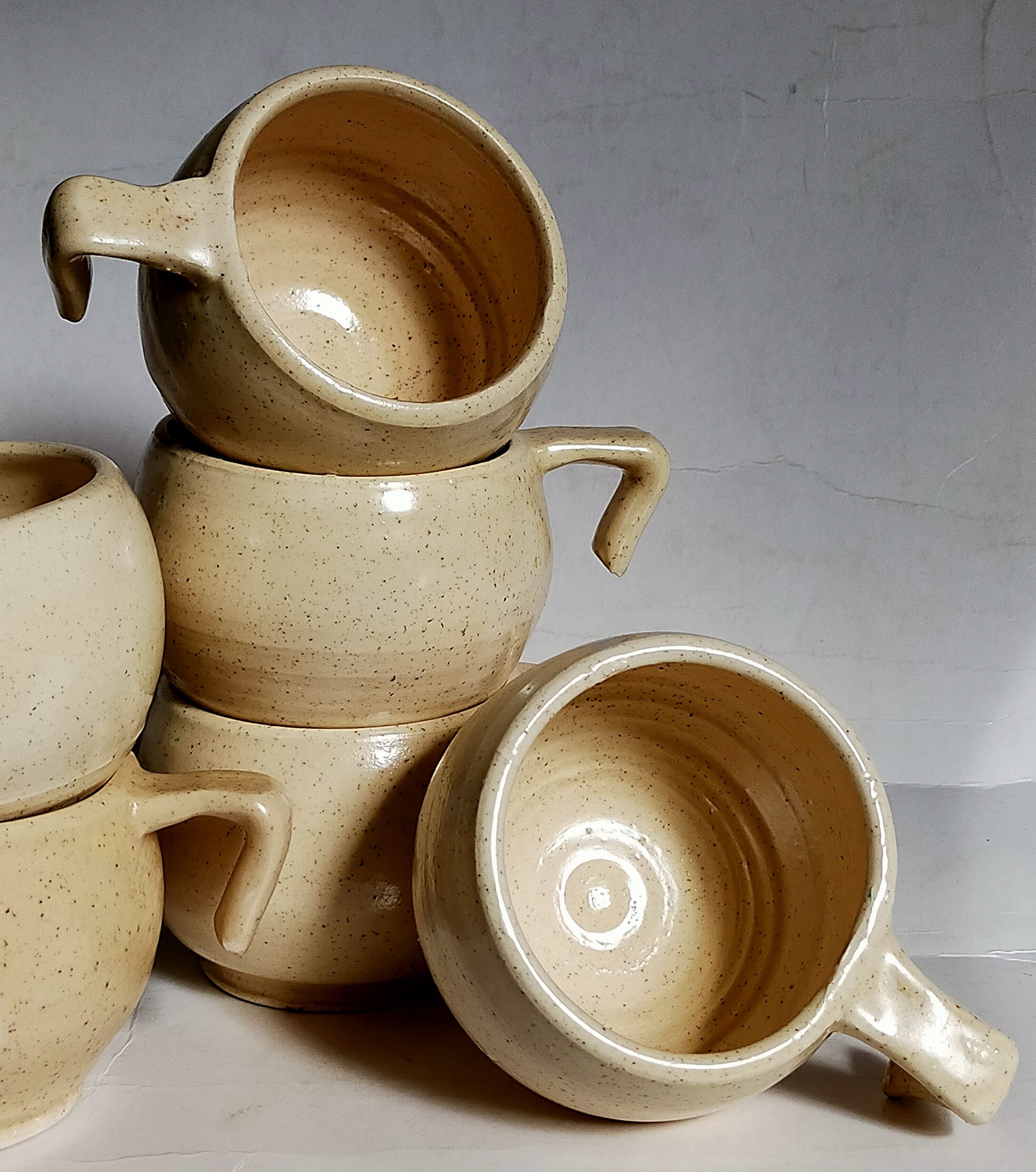 Six vintage potter's ceramic cups with vanilla enamel