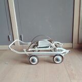 Old foldable stroller on metal wheels. Toy from the 50s