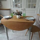 Walnut table with raised flaps, base on verdigris casters.
