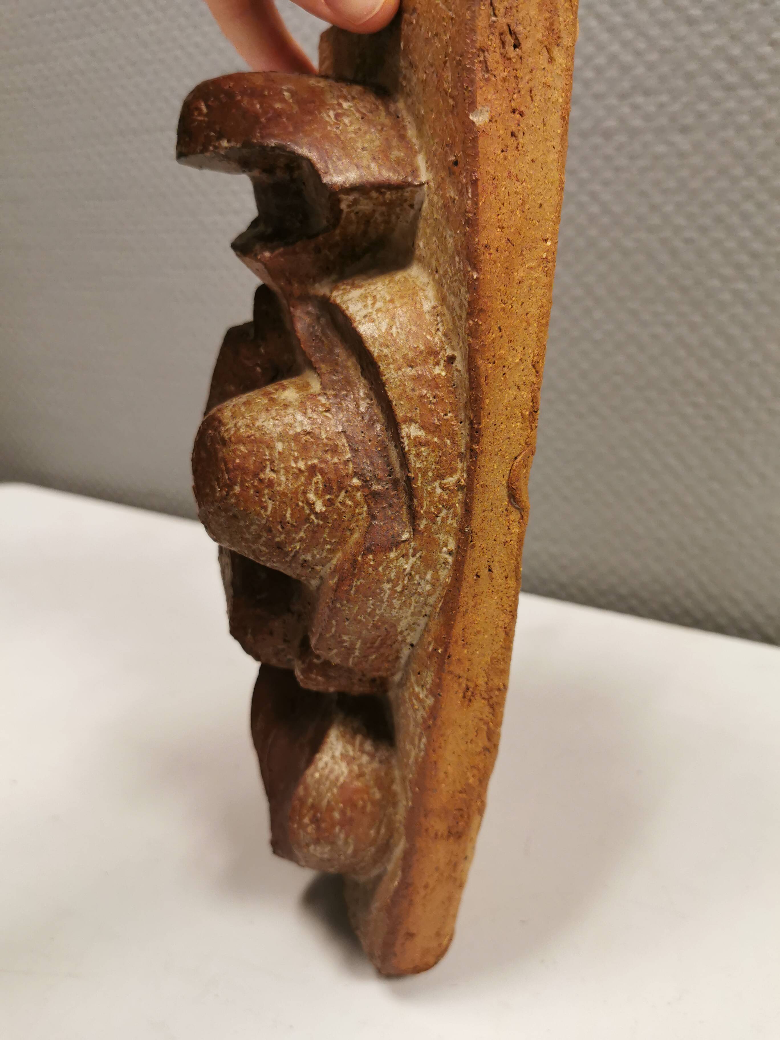 Ceramic relief portraying a lady. Emerging out of the background.