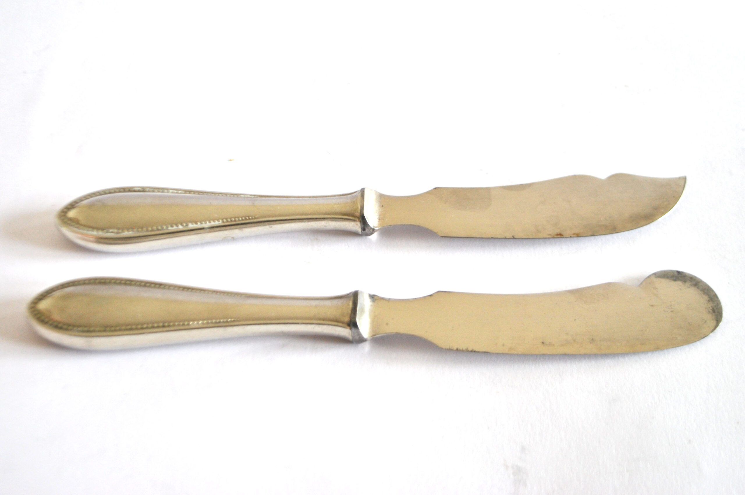 Two antique service knives in silver-plated metal, pearl frieze gowe alpacca.