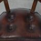 Set of two brown leather Chesterfield dining chairs in English style.