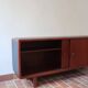 Teak enfilade, sliding doors, black faux leather top, 1970s.