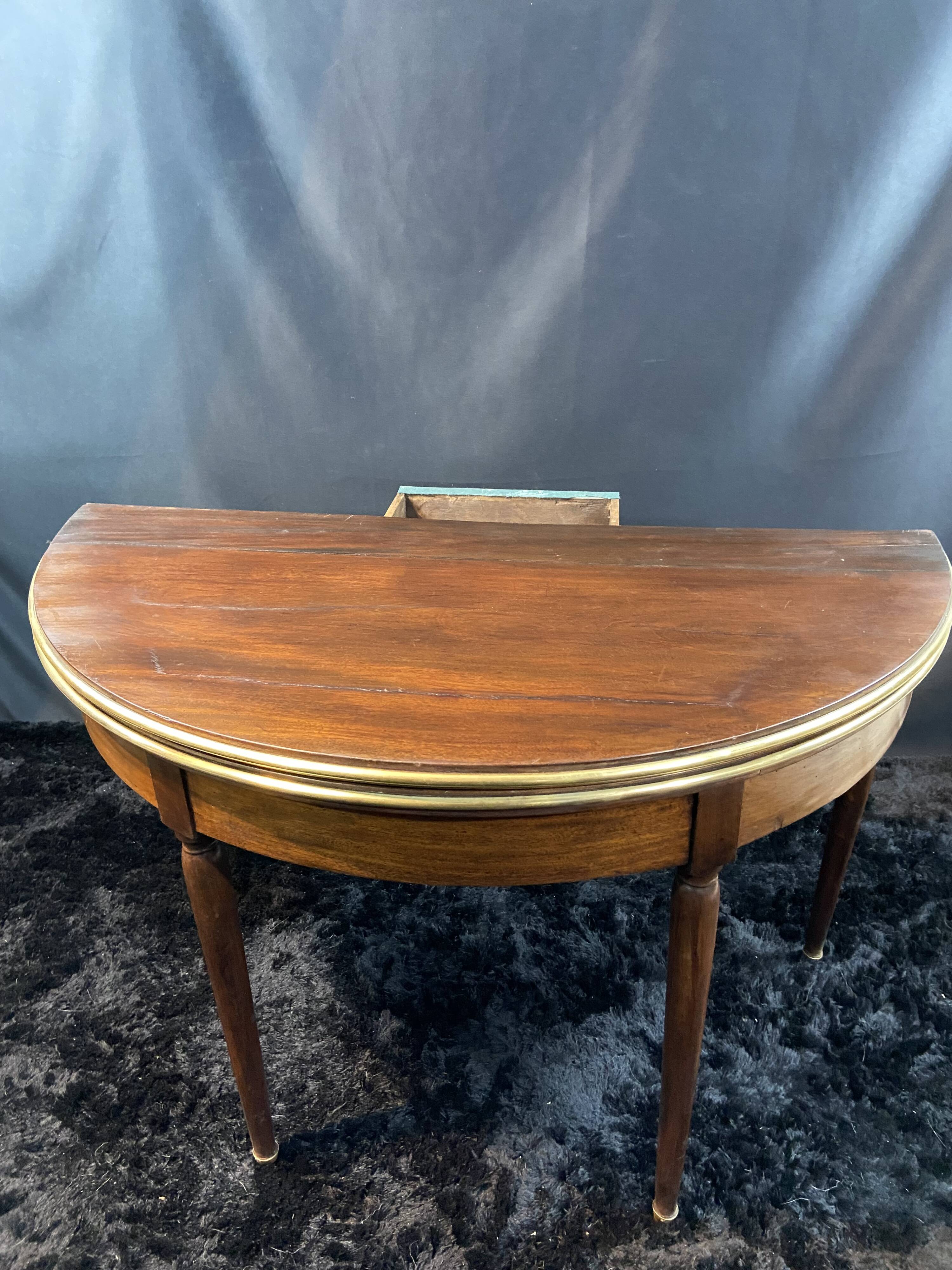 A Louis XVI period mahogany half-moon table forming a console/games table