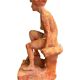 Painted plaster sculpture of a nude woman on a bench