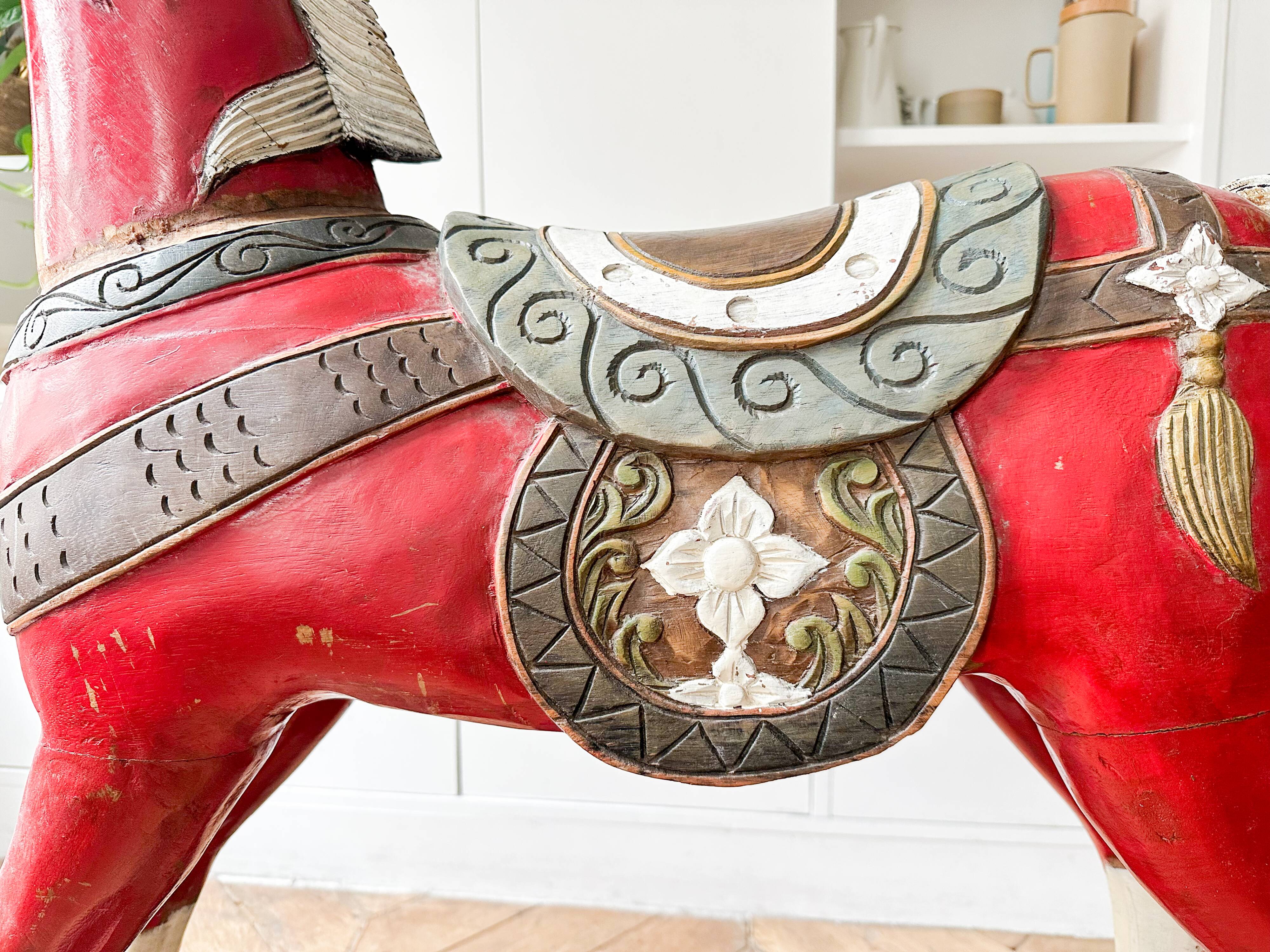 Large decorative rocking horse made of carved and hand-painted wood.