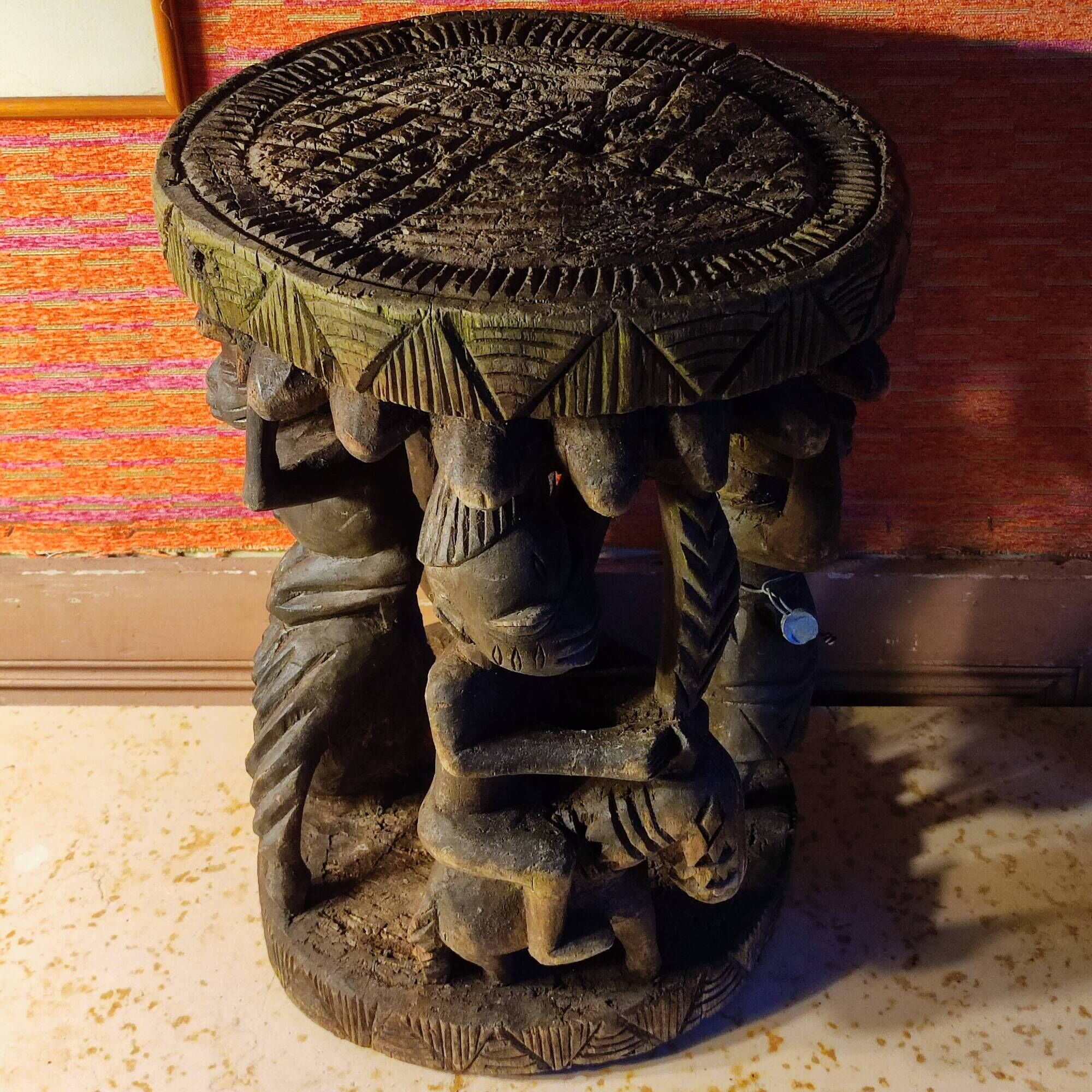 African wooden stool carved in the shapes of characters