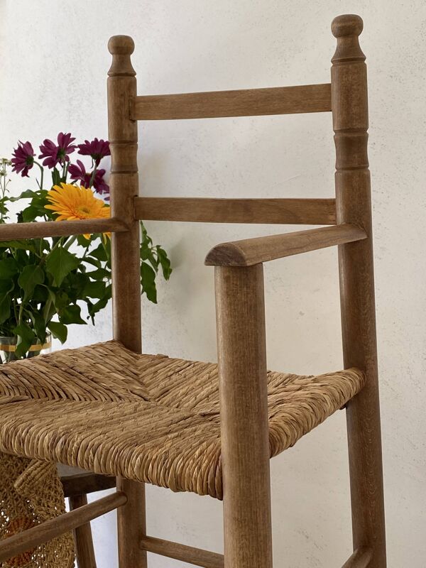 Ancienne chaise haute d’enfant en bois massif avec assise paillée.