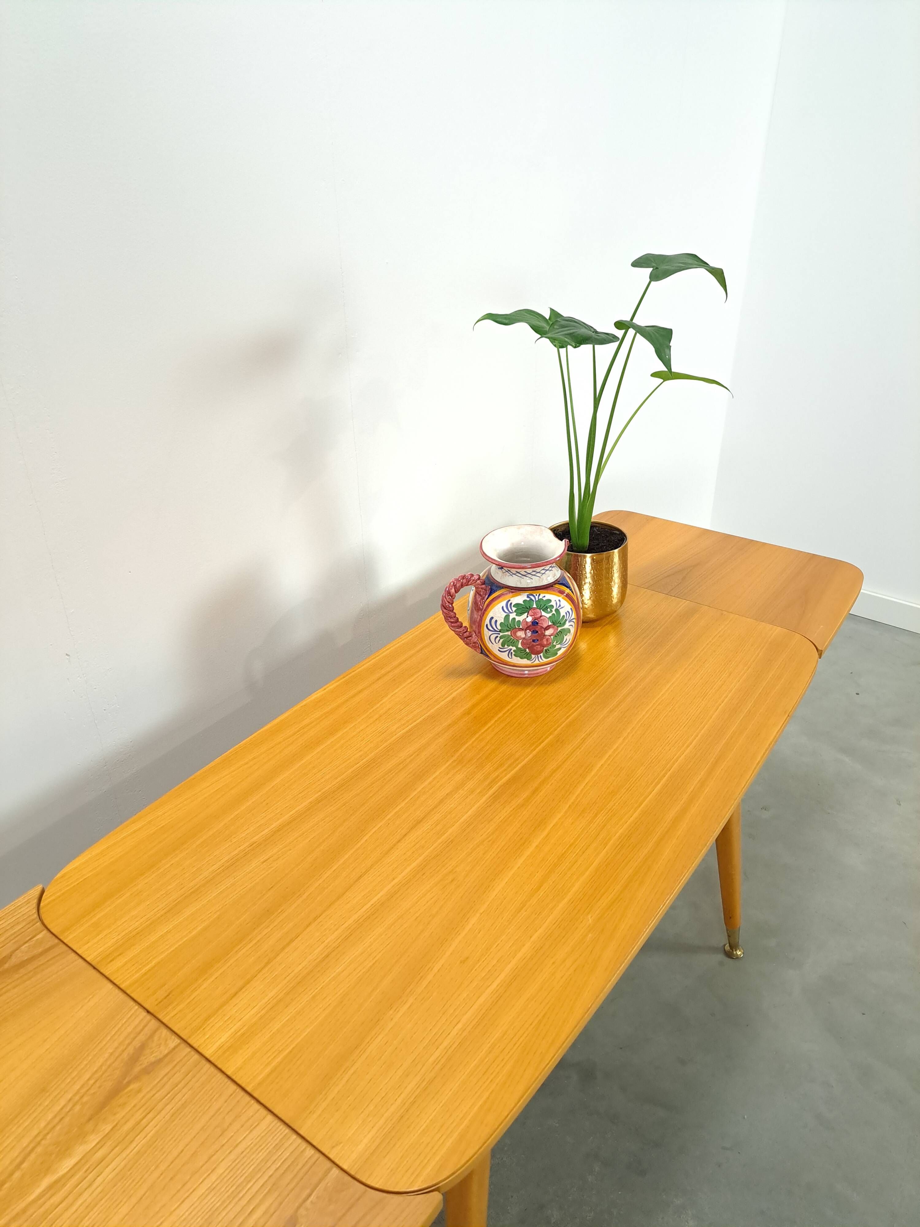 Vintage veneer table with pretty angular legs and brass at the base of the legs.